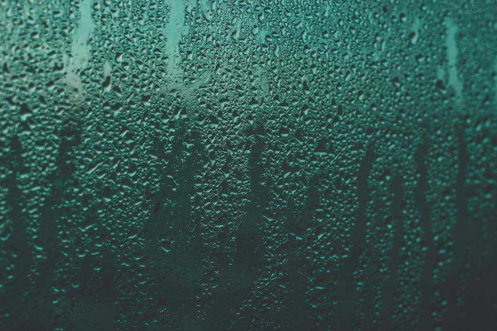 Close-up of rain droplets on a window creating an abstract texture.